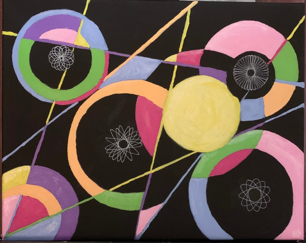 Closeup on a black canvas on an easel with pop art circles and lines in pink, purple, green, blue, and yellow, with four white spiral circles created with a spirograph.